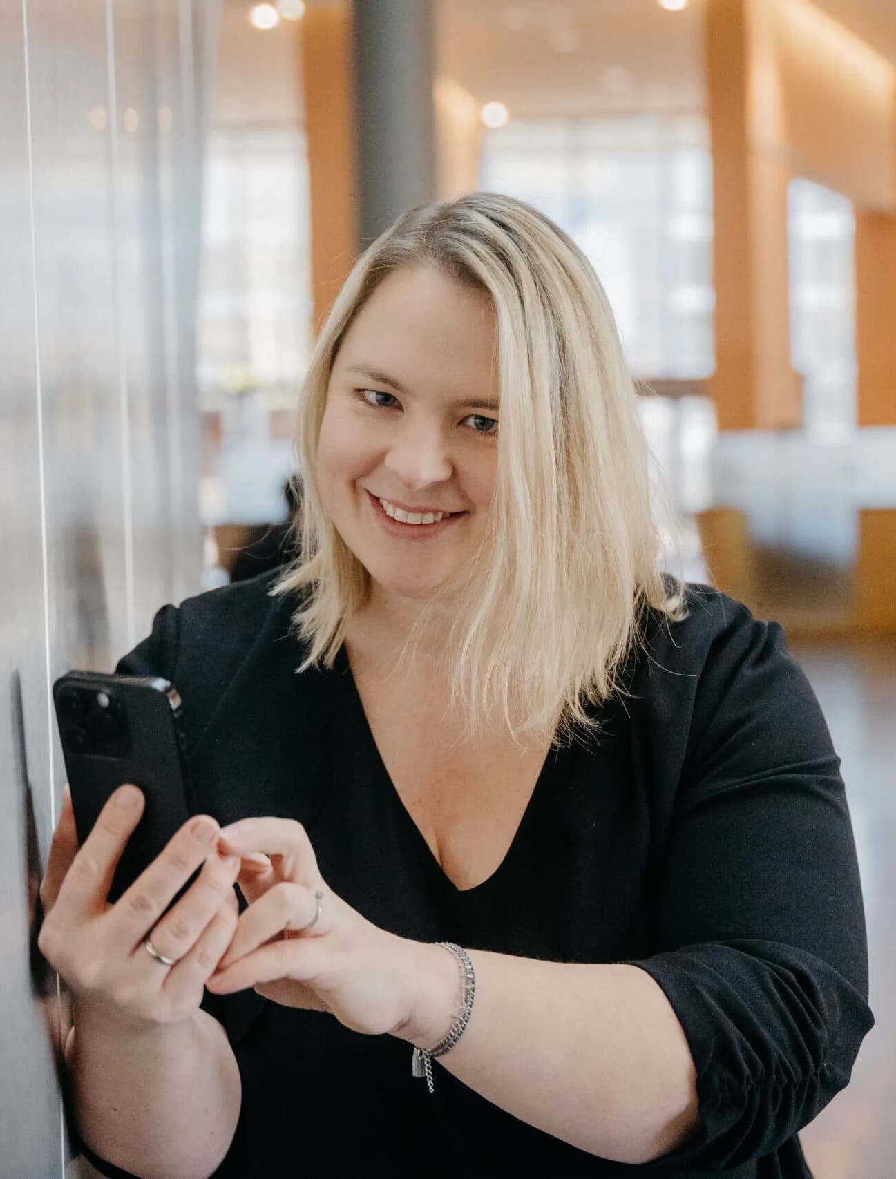 Eva Czaja lacht mit dem Smartphone in der Hand