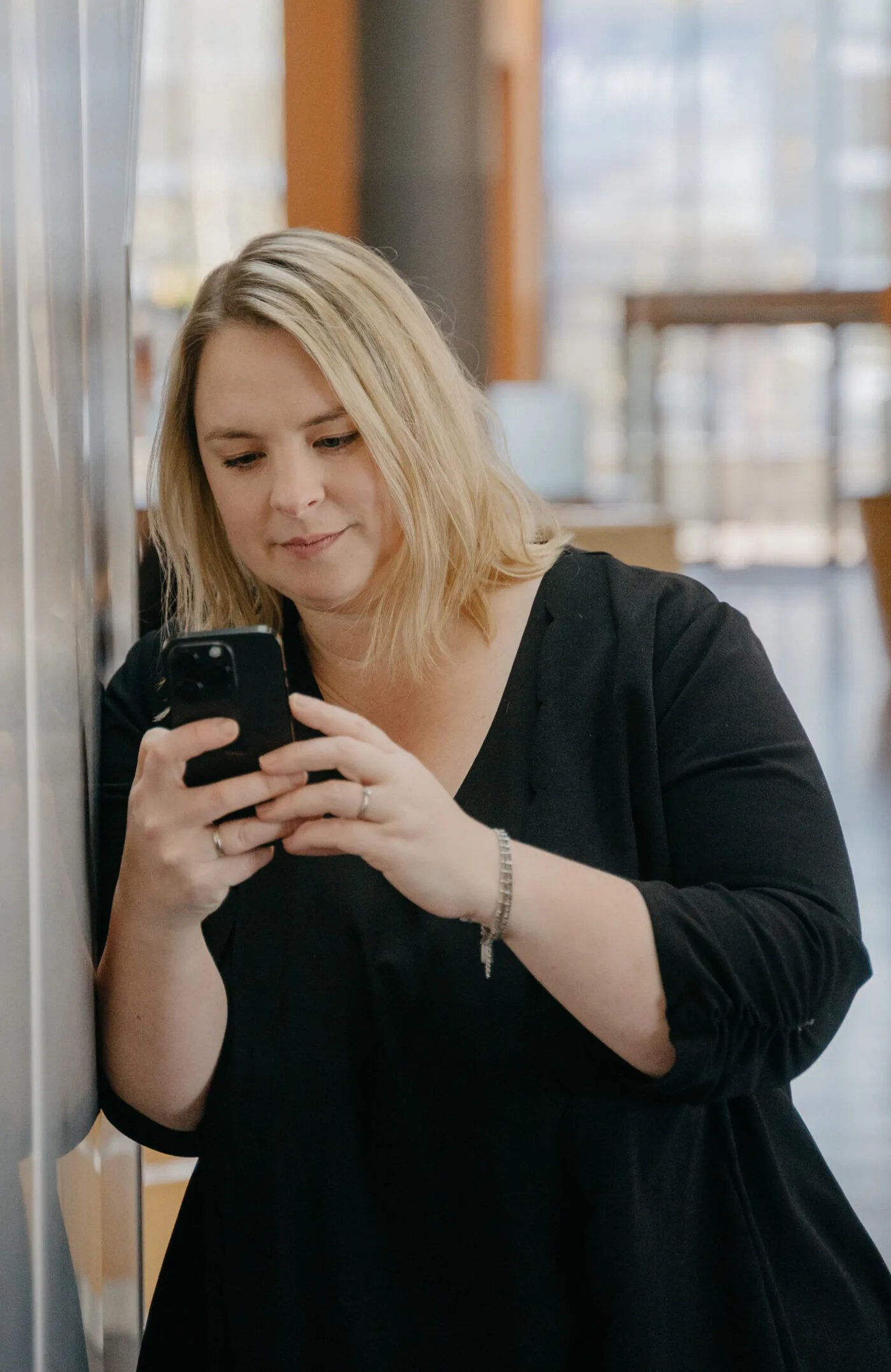 Eva Czaja steht mit dem Smartphone am Fenster