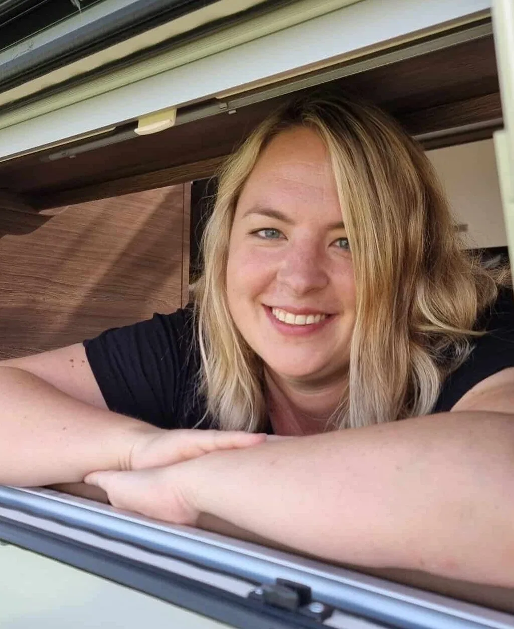 Eva Czaja lehnt lächelnd im Fenster eines Wohnwagens